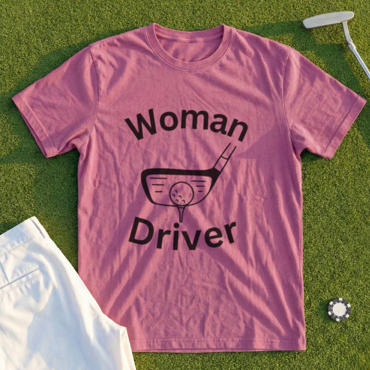 Pink t-shirt with "Woman Driver" text and golf club graphic on green grass.