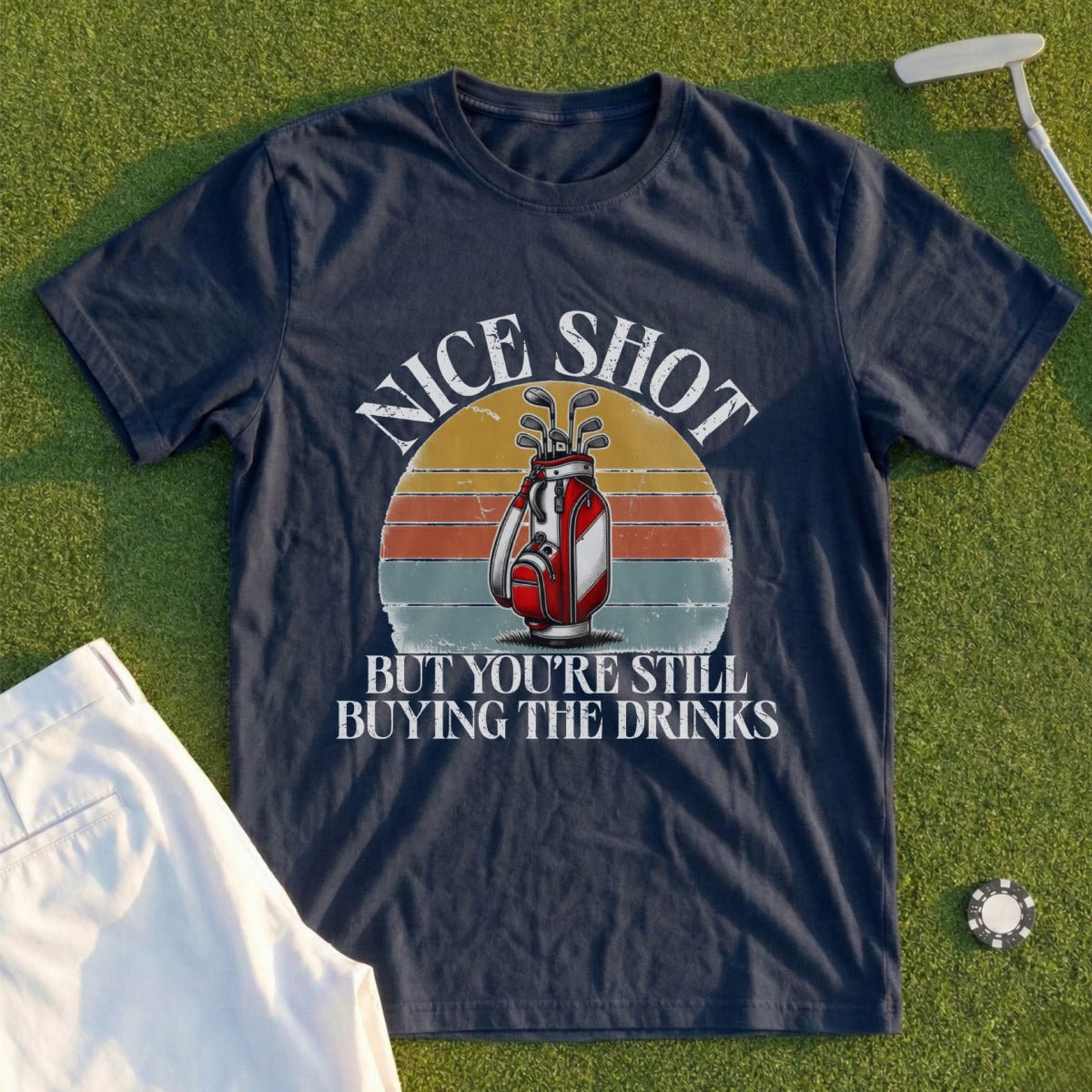 Navy t-shirt with golf bag graphic and text "Nice Shot But You're Still Buying The Drinks".