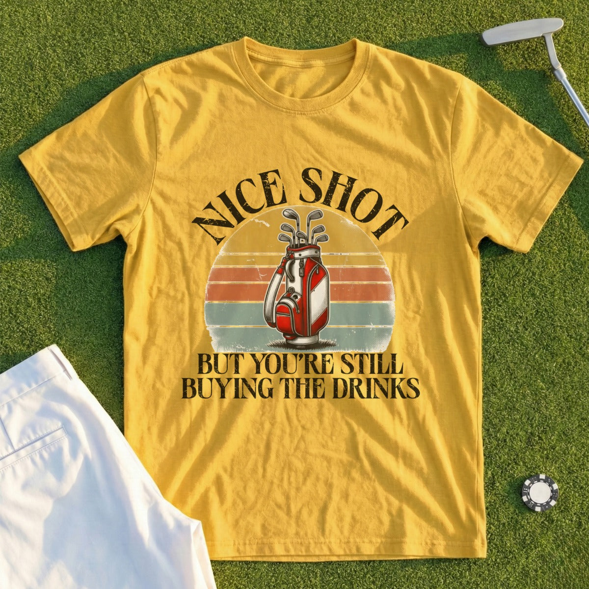Yellow t-shirt with "NICE SHOT BUT YOU'RE STILL BUYING THE DRINKS" and golf bag graphic.