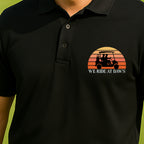 We Ride At Dawn Sunrise Performance Polo worn on the golf course, Black